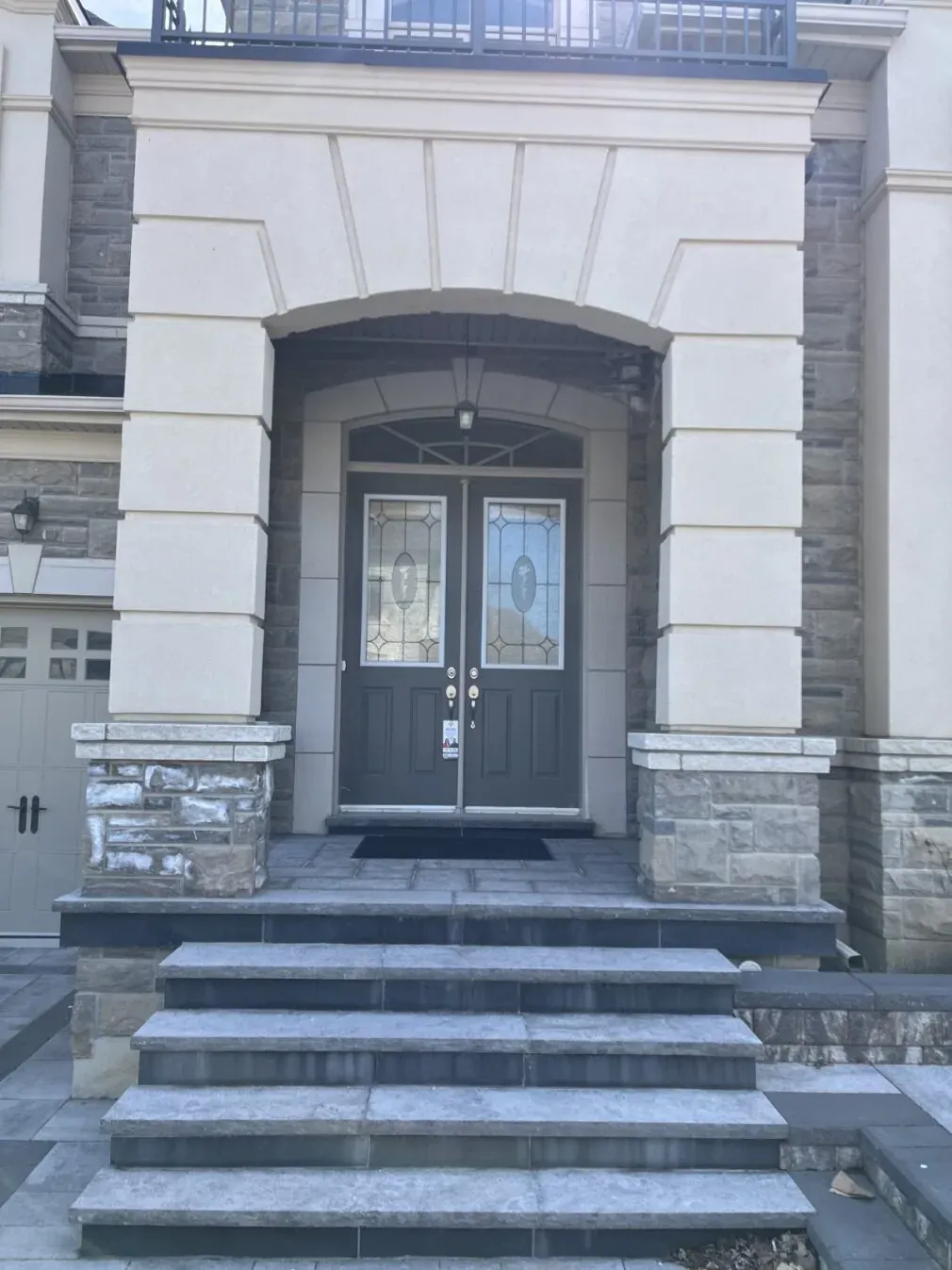 Charcoal double entry doors with decorative glass and stone steps in Richmond Hill