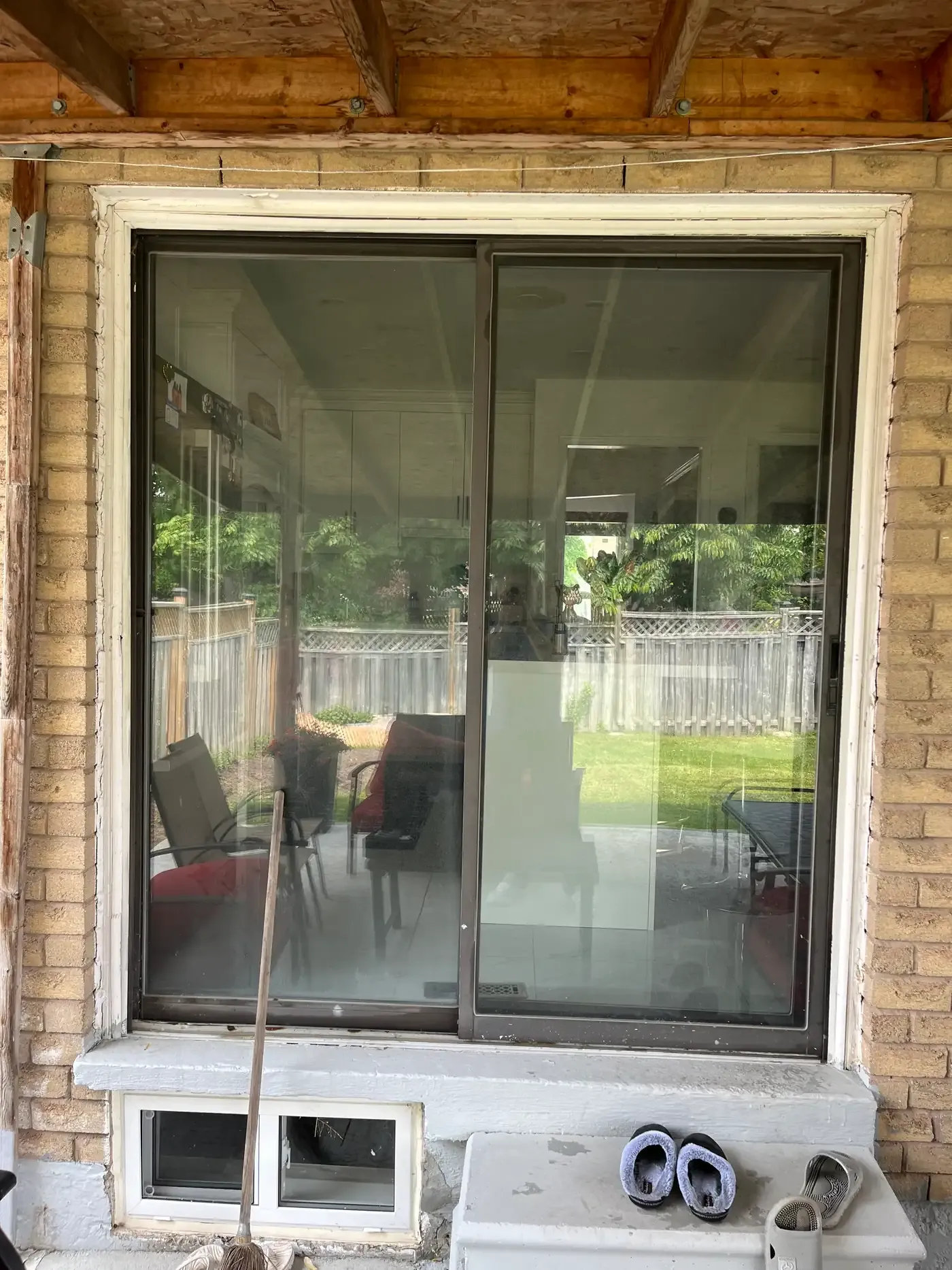Brown-framed sliding patio door on a brick Richmond Hill home viewed from outside