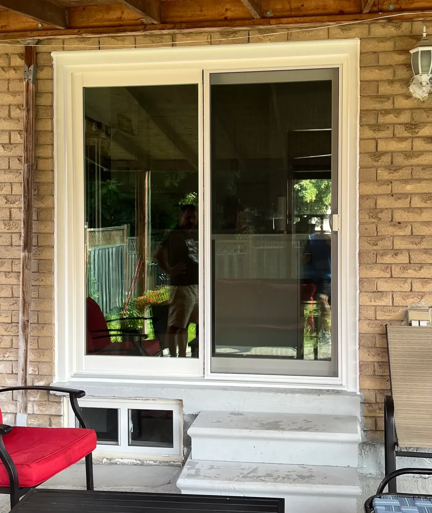 White-framed sliding patio door with screen on a brick home in Richmond Hill